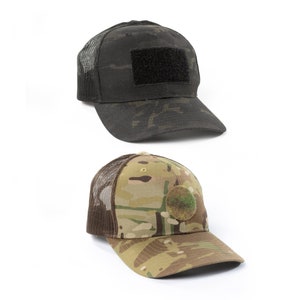 May include: Two camouflage trucker hats. One is black with a black velcro patch and the other is a green and brown camouflage with a green circle patch.