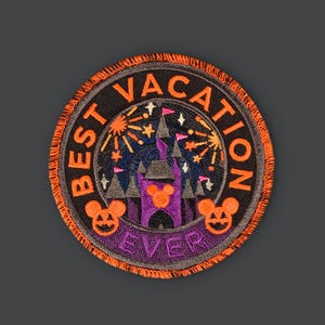 Pode incluir: Etiqueta bordada laranja e preta com uma silhueta de castelo, fogos de artifício e o texto "BEST VACATION EVER" em um círculo.