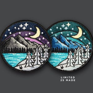 May include: Two embroidered patches depicting a nighttime scene with mountains, trees, a lake, a crescent moon, and stars. The patches are circular and have a black border. The text "LIMITED 25 MADE" is printed below the patches.