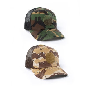 May include: Two camouflage trucker hats with mesh back panels. The hats have a brown patch on the front. One hat is green and brown camouflage, the other is tan and brown camouflage.