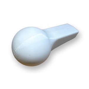 Może przedstawiać: Biały gwizdek z zaokrąglonym, kulistym zakończeniem i prostokątnym ustnikiem. Kuliste zakończenie ma koncentryczne okrągłe żłobienia. Gwizdek wykonany jest z gładkiego, solidnego materiału.