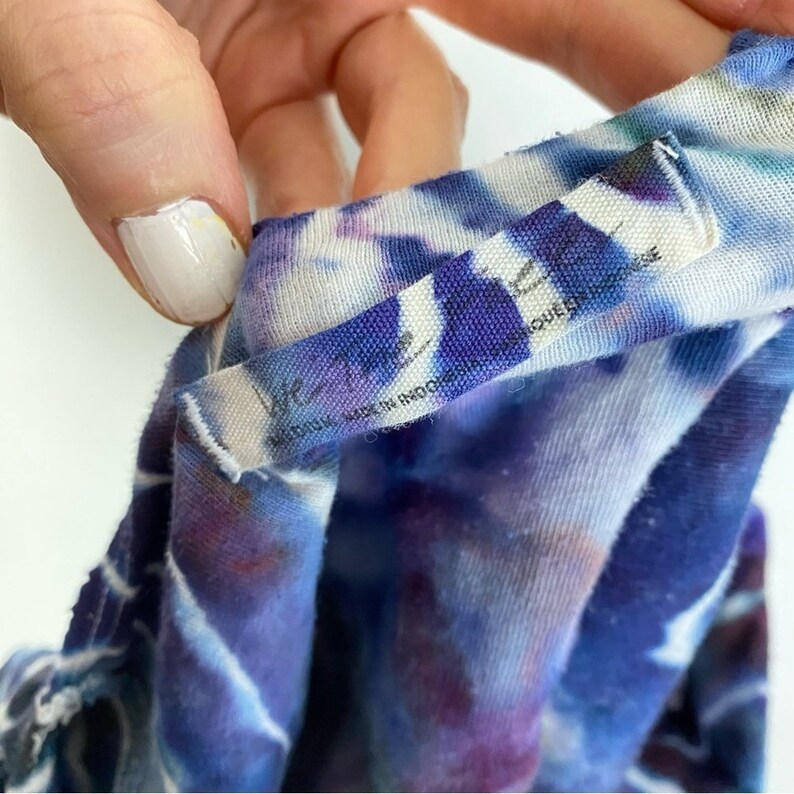 May include: Close-up of a blue and white tie-dye shirt with a tag that reads "Free People" and "Made in Indonesia".
