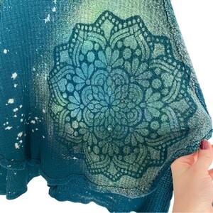 May include: Teal blue waffle knit fabric with a white bleached mandala design. The fabric has a distressed look with a faded, vintage feel.