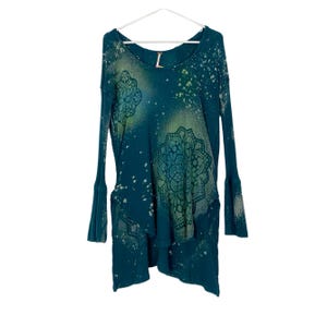 May include: Teal blue long-sleeved shirt with a green and white mandala design. The shirt has a distressed look with white splatter paint.