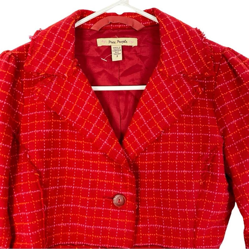 May include: Red and pink plaid blazer with a single button closure and a Free People label.