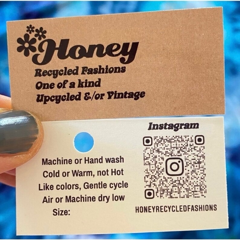 May include: A business card for *Honey Recycled Fashions* with the text "One of a kind Upcycled &/or Vintage" and a QR code for their Instagram page. The card also includes care instructions for the clothing: Machine or Hand wash Cold or Warm, not Hot Like colors, Gentle cycle Air or Machine dry low Size: