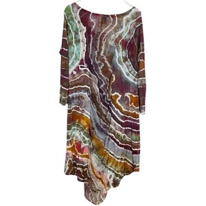 May include: A long-sleeved, asymmetrical dress with a tie-dye pattern in shades of brown, orange, green, and purple.