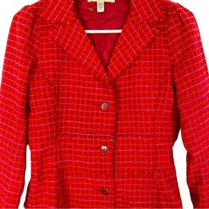 May include: Red blazer with a checkered pattern in pink and white. The blazer has a button closure and a collar.