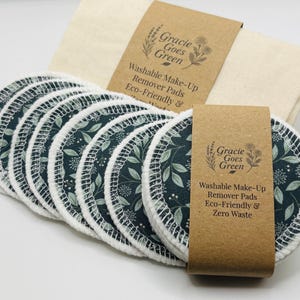 May include: Washable makeup remover pads with a dark teal floral design and white stitching. The pads are displayed with a beige cloth and a brown paper label that reads "Gracie Goes Green".
