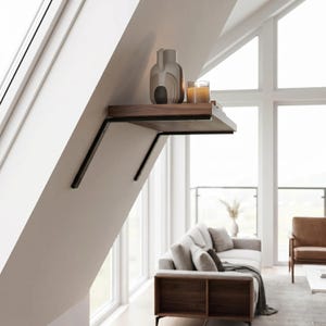 May include: A modern wall-mounted shelf with a dark wood surface and black metal brackets. The shelf holds a decorative vase and a lit candle in a glass. The shelf is mounted on a white wall in a room with large windows.
