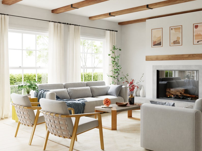 May include: A living room with a white sofa, two woven chairs, a coffee table, and a fireplace with a wood-burning fire. The room has large windows with white curtains and exposed wooden beams on the ceiling.