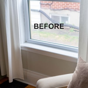 May include: A white window with white trim and a view of a brick building and green grass. The word "BEFORE" is written on the window.