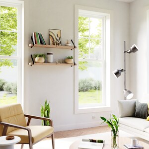 K&ouml;nnte beinhalten: Zwei Holzregale mit schwarzen Metallkonsolen an einer wei&szlig;en Wand montiert. Die Regale sind mit B&uuml;chern, Pflanzen und Dekorationsgegenst&auml;nden geschm&uuml;ckt. Ein gelber Sessel steht vor den Regalen.