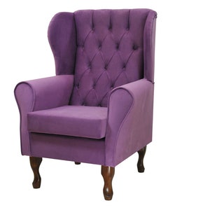 May include: A purple wingback armchair with a tufted back and seat. The chair has wooden legs and a classic design.