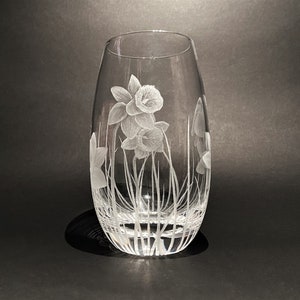 K&ouml;nnte beinhalten: Eine klare Glasvase mit einem gravierten Design aus wei&szlig;en Narzissen.