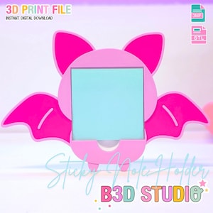 May include: A pink bat-shaped sticky note holder with a light blue note inside. The holder has a square opening for the note and wings on either side. Text on the image reads "3D PRINT FILE" and "Sticky Note Holder".