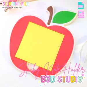 May include: A red apple-shaped sticky note holder with a yellow square in the center. The holder has a green leaf and a brown stem. Text on the image reads "3D PRINT FILE" and "Sticky Note Holder B3D STUDIO".