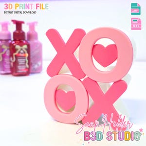 May include: A pink and white soap holder with the letters X and O, each with a heart cutout. The holder has the text "Soap Holder" and "B3D STUDIO". The image also includes soap dispensers and the text "3D PRINT FILE" and "INSTANT DIGITAL DOWNLOAD".