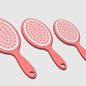Peut inclure: Trois brosses &agrave; cheveux ovales roses avec une bordure blanche et de petites soies. Chaque brosse a une poign&eacute;e avec un trou pour l'accrocher. Les brosses sont dispos&eacute;es en rang&eacute;e, de taille d&eacute;croissante.