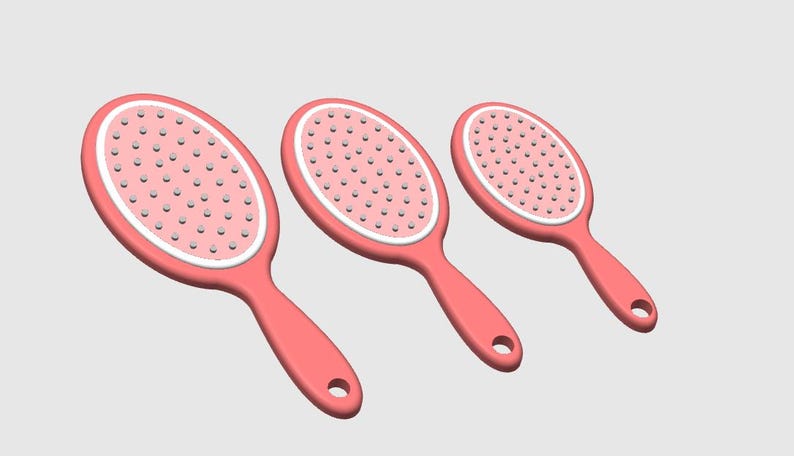 Peut inclure: Trois brosses &agrave; cheveux ovales roses avec une bordure blanche et de petites soies. Chaque brosse a une poign&eacute;e avec un trou pour l'accrocher. Les brosses sont dispos&eacute;es en rang&eacute;e, de taille d&eacute;croissante.