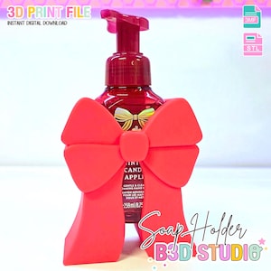 May include: A red bow-shaped soap holder with a hand soap bottle. The soap bottle is red with a gold bow design. The text "3D PRINT FILE" and "INSTANT DIGITAL DOWNLOAD" are visible.