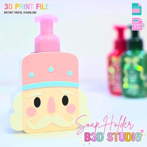 Può includere: Erogatore di sapone rosa e crema a forma di schiaccianoci, con una pompa rosa. Presenta finiture azzurre e tre punti azzurri. Il testo "Soap Holder" e "B3D STUDIO" sono visibili.
