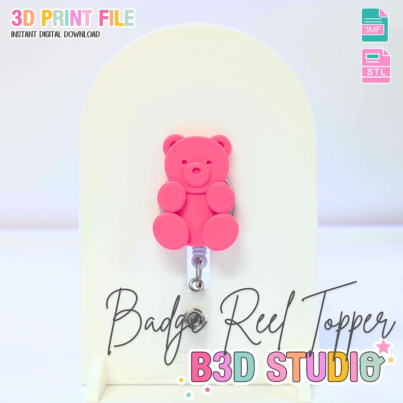 May include: A pink teddy bear badge reel topper. The topper is attached to a white retractable reel. The image also includes the text "Badge Reel Topper" and "B3D STUDIO". The words "3D PRINT FILE" and "INSTANT DIGITAL DOWNLOAD" are also visible.