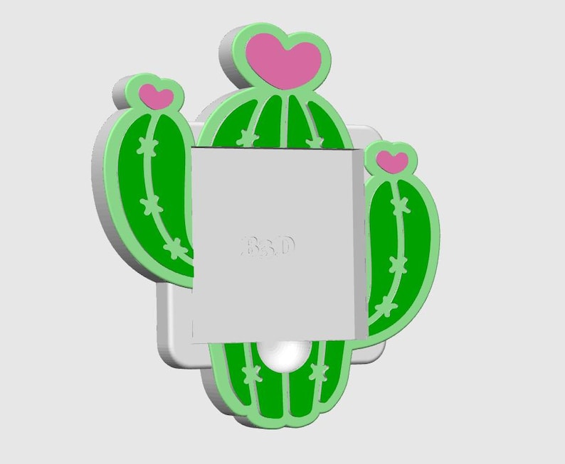 May include: A green and pink cactus-shaped wall decor with a white base. The cactus has a heart-shaped top and star-shaped details. The text "R&D" is visible on the white surface.