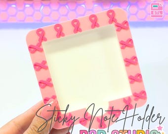 Puede incluir: Un soporte para notas adhesivas rosa con detalles de lazos rosas. El soporte tiene forma cuadrada con una abertura rectangular para las notas. El texto "Sticky Note Holder" y "B3D STUDIO" son visibles. También se ven las palabras "3D PRINT FILE" y "INSTANT DIGITAL DOWNLOAD".