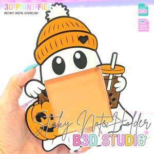 May include: A white ghost-shaped sticky note holder with an orange beanie and a pumpkin. The ghost holds a boba tea and a blank orange sticky note. The text "Sticky Note Holder" and "B3D STUDIO" are visible.