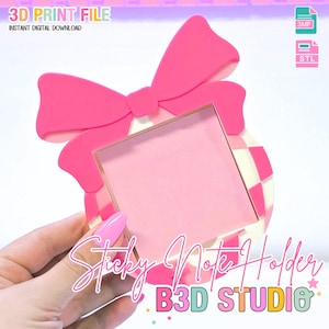 Pode incluir: Um porta-notas autocolantes rosa com um design de laço. O suporte tem uma forma quadrada com interior rosa e borda dourada. O texto "Sticky Note Holder" e "B3D STUDIO" são visíveis.