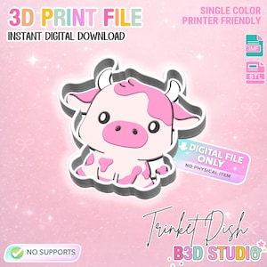 Puede incluir: Un diseño digital para un joyero con forma de vaca, con colores rosa y blanco. La imagen incluye el texto "3D PRINT FILE" y "INSTANT DIGITAL DOWNLOAD". Se describe como "SINGLE COLOR PRINTER FRIENDLY" y "DIGITAL FILE ONLY". También se ven las palabras "NO SUPPORTS".