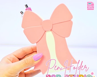 Puede incluir: Un portalápices rosa en forma de lazo con una franja amarilla clara en el centro. Los textos "Pen Holder" y "B3D STUDIO" son visibles. La imagen también incluye el texto "3D PRINT FILE" y "INSTANT DIGITAL DOWNLOAD".