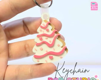 May include: A Christmas tree-shaped keychain with a white base, pink icing, and heart-shaped sprinkles. The keychain has a silver ring and a clear plastic attachment. Text on the image reads "3D PRINT FILE" and "INSTANT DIGITAL DOWNLOAD". The text "Keychain B3D STUDIO" is also visible.
