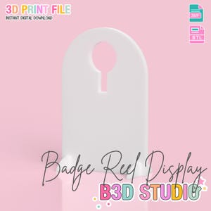 May include: A white badge reel display with a keyhole-shaped opening at the top. The text "Badge Reel Display" is written in cursive script. The background is a soft pink with the text "3D PRINT FILE" and "INSTANT DIGITAL DOWNLOAD".
