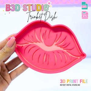 Puede incluir: Un joyero rosa brillante con forma de labios, sostenido por una mano. El plato presenta diseños detallados de líneas de labios. La imagen incluye el texto "B3D STUDIO Trinket Dish" y "3D PRINT FILE INSTANT DIGITAL DOWNLOAD".