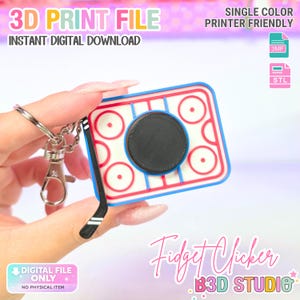 May include: A 3D print file for a rectangular hockey rink fidget clicker keychain. The design features a white rink surface with red markings, a blue border, a black circular center button, and a black hockey stick charm attached to a metal ring.