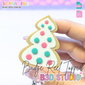 May include: A Christmas tree-shaped badge reel topper with a white frosted design, adorned with pink and teal polka dots. The topper has a tan border and the text "Badge Reel Topper" and "B3D STUDIO". The image also includes the text "3D PRINT FILE" and "INSTANT DIGITAL DOWNLOAD".