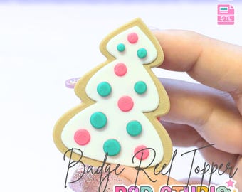 May include: A Christmas tree-shaped badge reel topper with a white frosted design, adorned with pink and teal polka dots. The topper has a tan border and the text "Badge Reel Topper" and "B3D STUDIO". The image also includes the text "3D PRINT FILE" and "INSTANT DIGITAL DOWNLOAD".