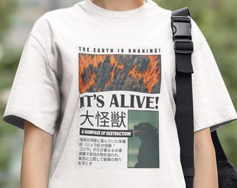 May include: White t-shirt with a graphic print of a monster with flames and the text "THE EARTH IS SHAKING! IT'S ALIVE! 大怪獣 A RAMPAGE OF DESTRUCTION!" in Japanese and English.