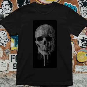 May include: Black t-shirt featuring a grayscale skull design. The skull is depicted with a matrix-style effect, creating a digital aesthetic. The shirt is a classic crew neck style, suitable for casual wear.