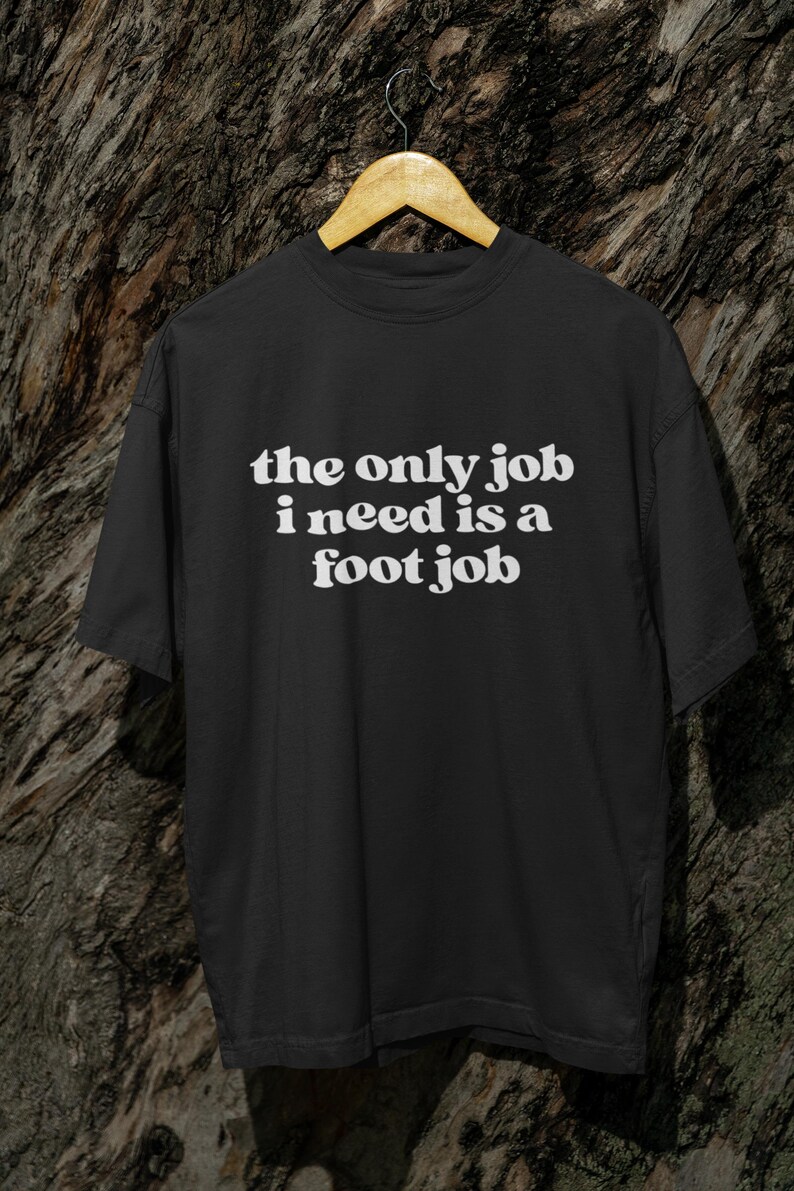 Puede incluir: Camiseta negra con texto blanco que dice "the only job i need is a foot job".