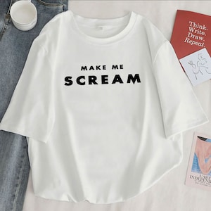 May include: White t-shirt with black text that reads "MAKE ME SCREAM".