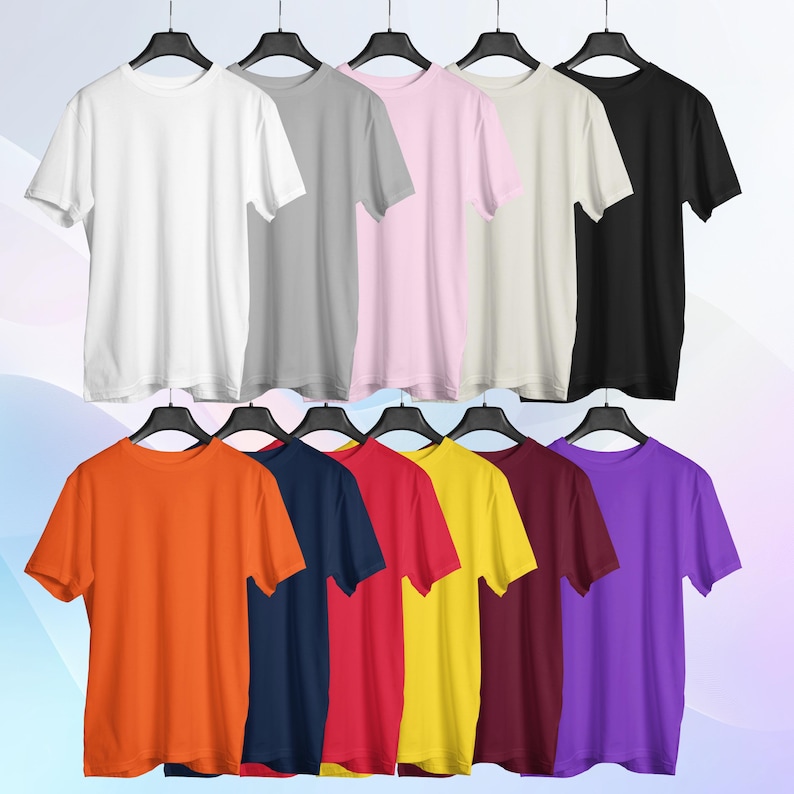 May include: Ten plain t-shirts in various colors hanging on hangers. The colors are white, gray, pink, beige, black, orange, navy blue, red, yellow, and purple.