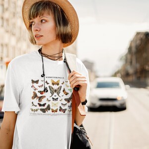 Puede incluir: Una camiseta blanca con una ilustraci&oacute;n vintage de mariposas impresa en la parte delantera. La ilustraci&oacute;n se titula "Schmetterlinge II".