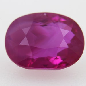Peut inclure: Une pierre précieuse ovale de couleur rose vif avec une taille facetée. La pierre précieuse est placée sur un fond blanc.