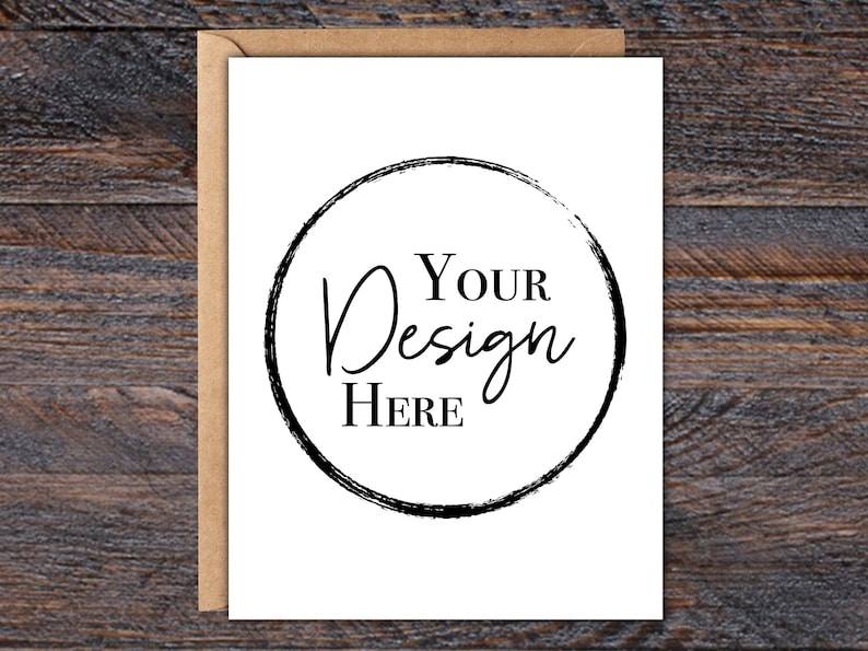 Puede incluir: Una tarjeta de felicitaci&oacute;n en blanco con un sobre de papel kraft. La tarjeta blanca presenta un dise&ntilde;o circular negro con las palabras "Your Design Here" en un estilo manuscrito. El fondo es una superficie de madera oscura.