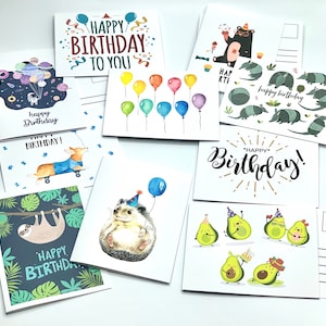 May include: Assortment of colorful birthday cards featuring various illustrations, including a sloth, a hedgehog, a corgi, avocados, armadillos, and balloons. The cards have different greetings, such as "Happy Birthday", "Happy Birthday to You", and "Happy Birthday!"
