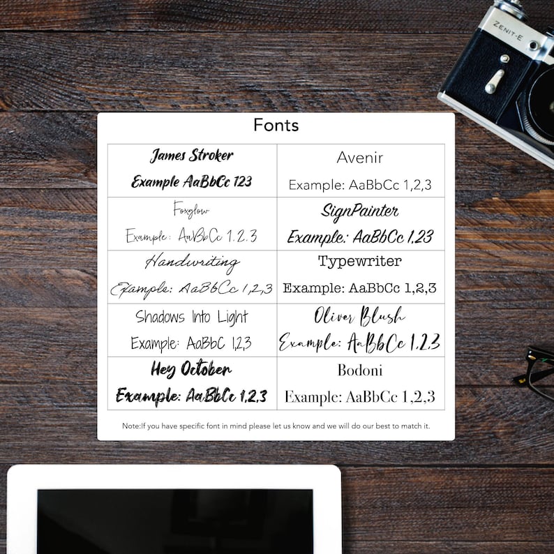 Puede incluir: Una hoja blanca muestra ejemplos de fuentes, incluyendo James Stroker y Handwriting, con texto de muestra en varios estilos. La hoja est&aacute; sobre una superficie de madera, con una c&aacute;mara y gafas en el fondo. La palabra "Fonts" est&aacute; en la parte superior.