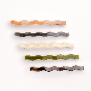May include: Set of six wavy hair clips in various colors, including peach, gray, cream, green, and brown.